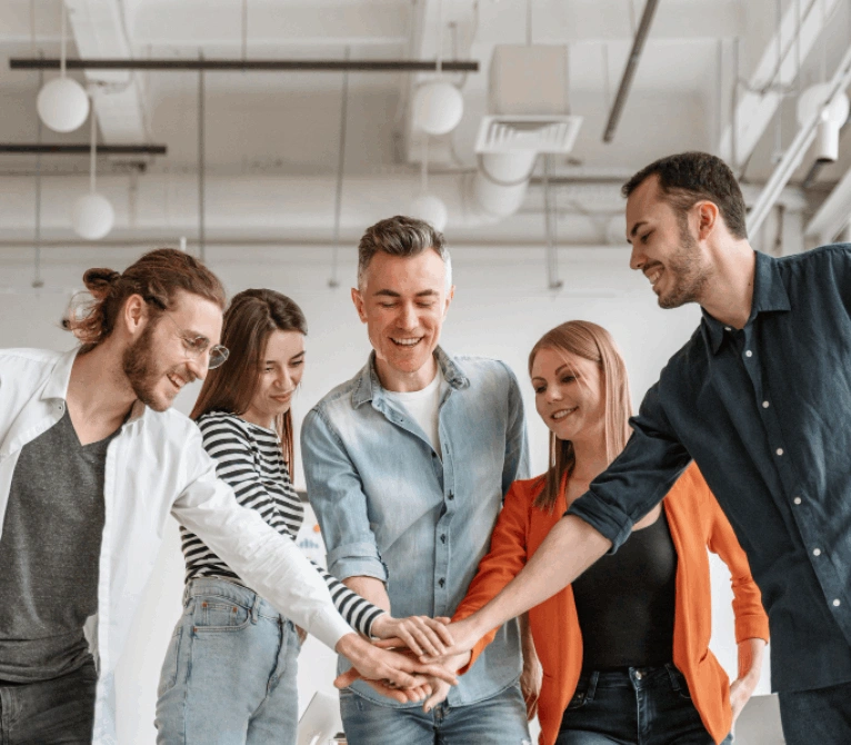Team members stacking hands to show unity and collaboration